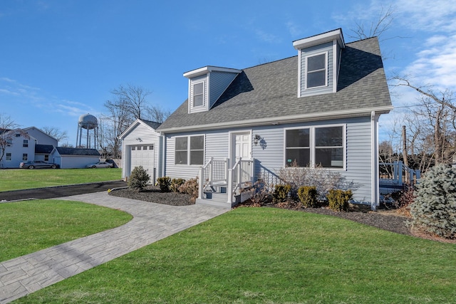 cape cod-style house with a garage, an outdoor structure, and a front lawn