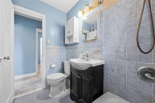 bathroom featuring vanity, toilet, tile patterned flooring, and tile walls