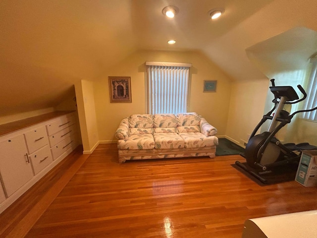 exercise area featuring vaulted ceiling and light hardwood / wood-style floors