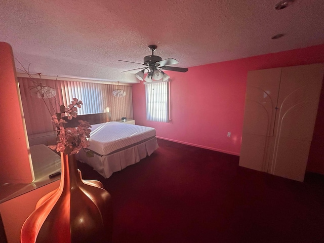 bedroom with ceiling fan, carpet floors, and a textured ceiling