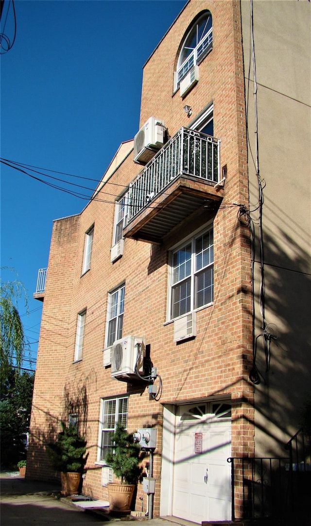 view of building exterior with a garage, ac unit, and central AC