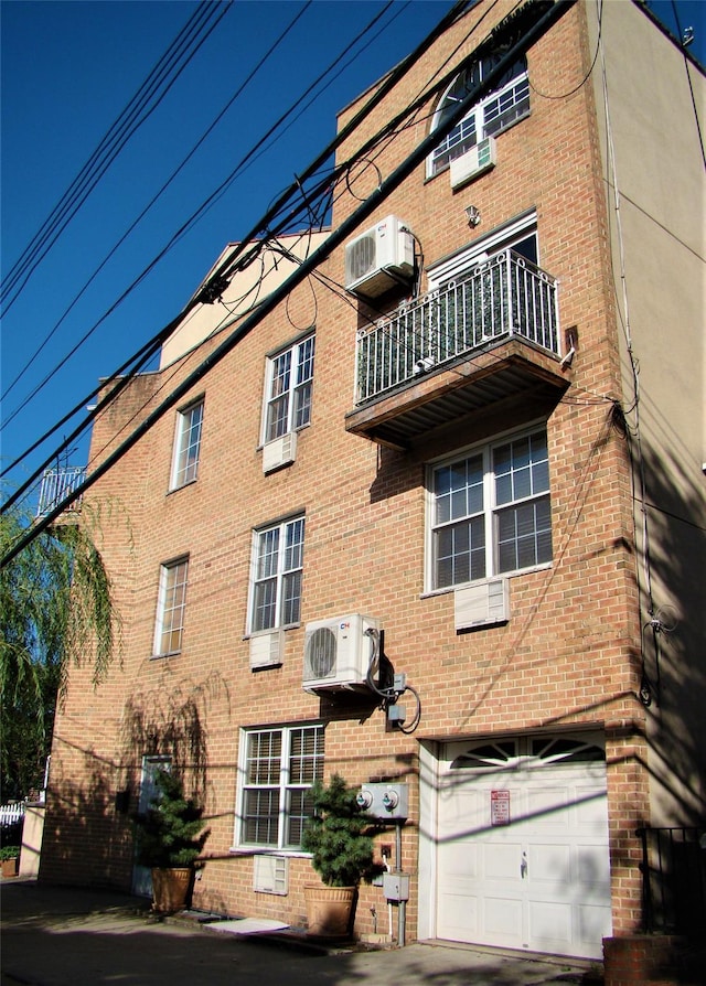 view of property featuring a garage and ac unit