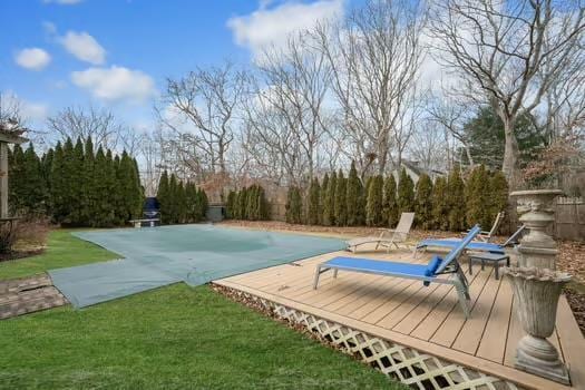 view of pool featuring a deck, a patio, and a lawn