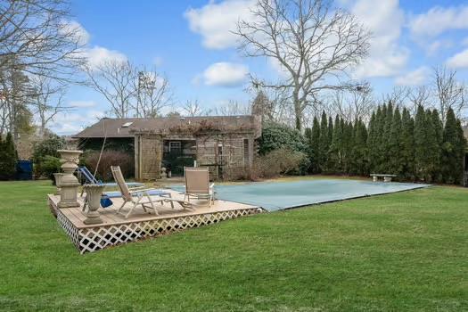 rear view of property with a yard and a covered pool