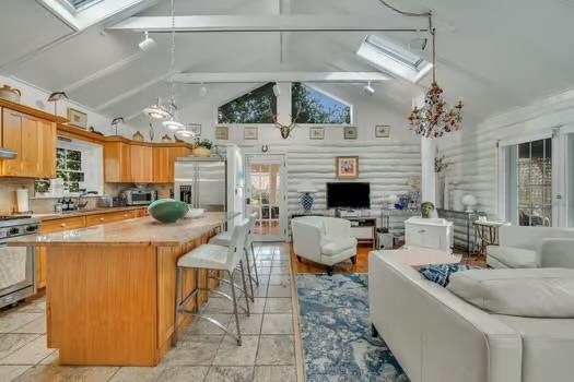 kitchen featuring range, stainless steel fridge, a skylight, and a kitchen island