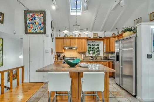 kitchen featuring a center island, high end fridge, backsplash, and a skylight