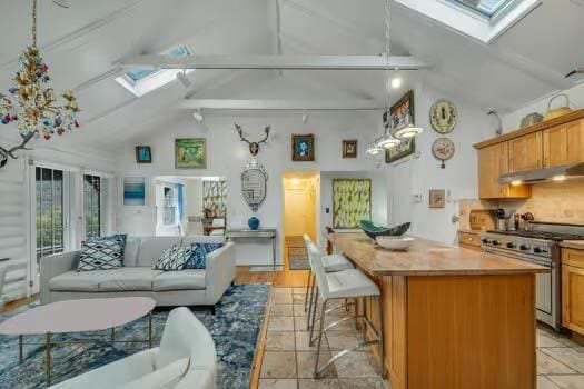 kitchen with high end stainless steel range, a skylight, high vaulted ceiling, and beamed ceiling