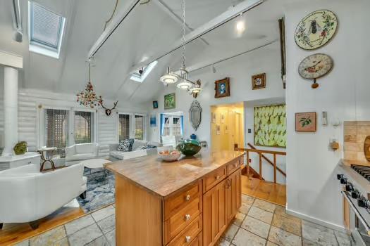 kitchen featuring high end stainless steel range, track lighting, decorative light fixtures, and a skylight