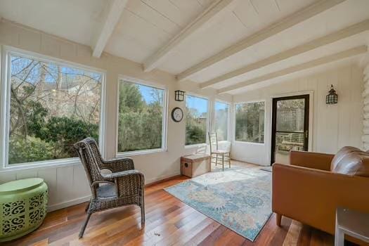 sunroom featuring plenty of natural light and vaulted ceiling with beams