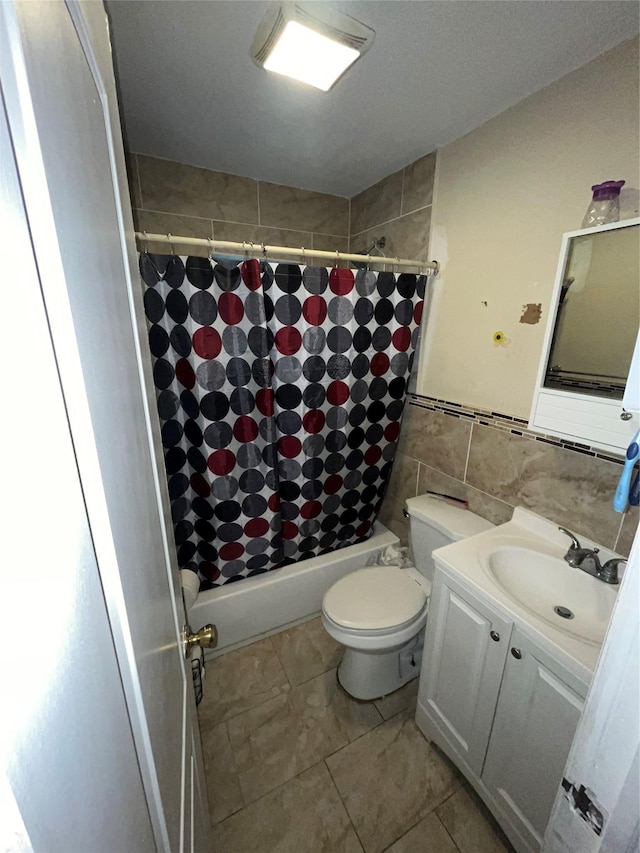 full bathroom featuring tile walls, vanity, toilet, and shower / bath combo with shower curtain