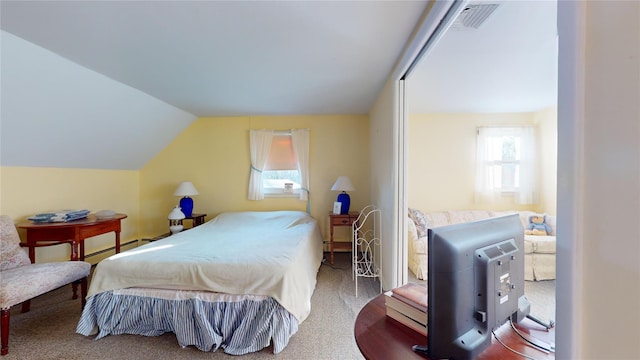 bedroom with carpet floors, vaulted ceiling, and a baseboard heating unit