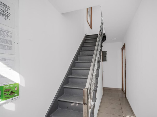 stairway featuring tile patterned floors and electric panel