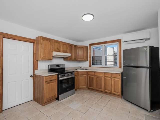 kitchen with sink, tasteful backsplash, a wall mounted AC, light tile patterned floors, and appliances with stainless steel finishes