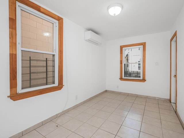 unfurnished room featuring light tile patterned floors and an AC wall unit