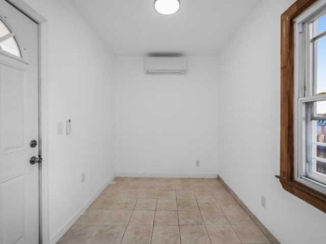 interior space with light tile patterned floors and a wall unit AC