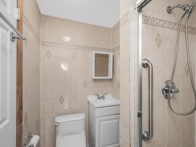 bathroom featuring vanity, tile walls, toilet, and walk in shower