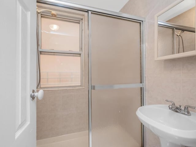 bathroom featuring tile walls, sink, and walk in shower