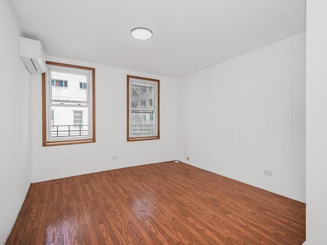 empty room with hardwood / wood-style flooring and a wall unit AC