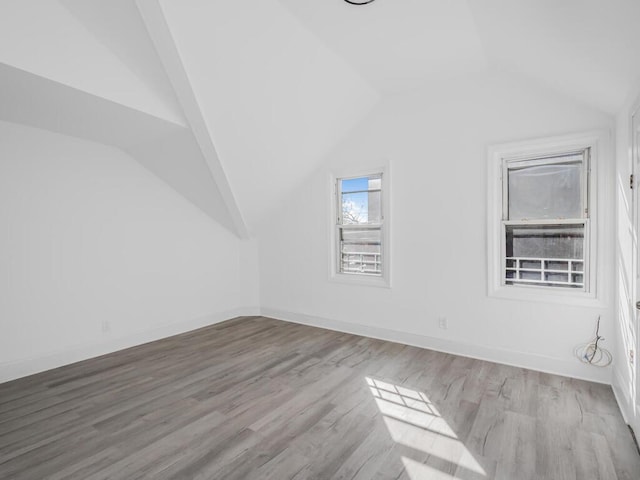 bonus room with lofted ceiling and light hardwood / wood-style floors