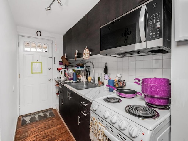 kitchen featuring sink, white electric range oven, dark hardwood / wood-style floors, and decorative backsplash