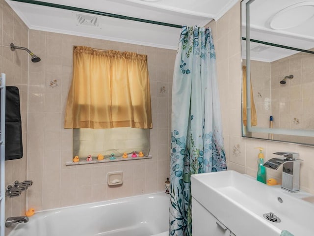 bathroom with shower / tub combo with curtain, sink, ornamental molding, and tile walls