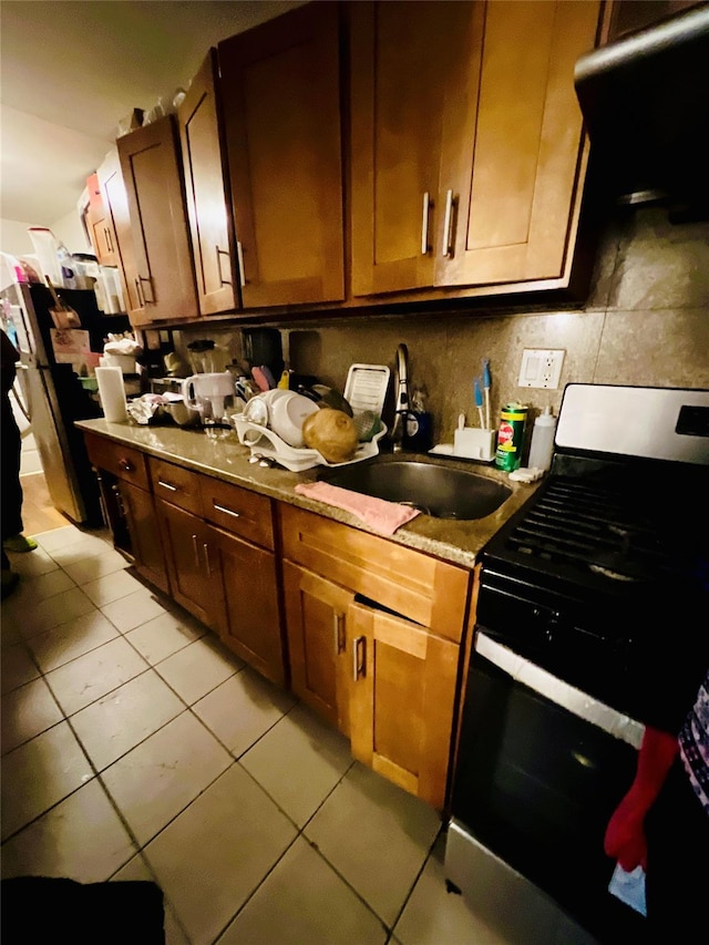 kitchen with extractor fan, tasteful backsplash, sink, light tile patterned floors, and gas stove