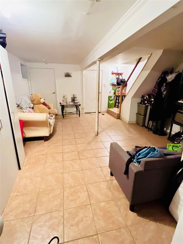 basement featuring ornamental molding and light tile patterned floors