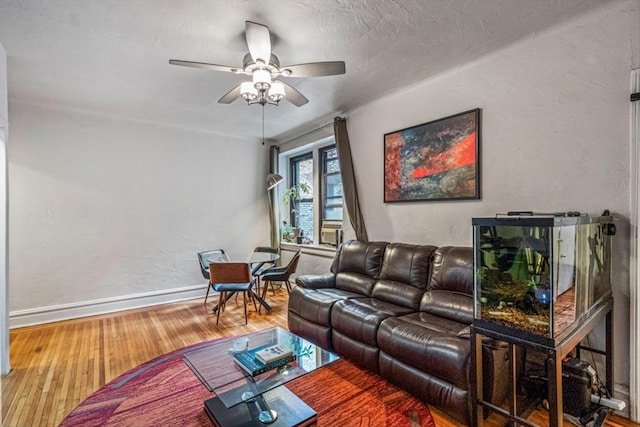 living room featuring wood-type flooring and ceiling fan