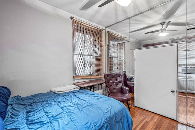 bedroom featuring hardwood / wood-style flooring, ceiling fan, and a closet