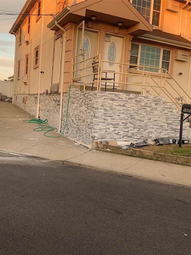 exterior entry at dusk with a wall mounted AC