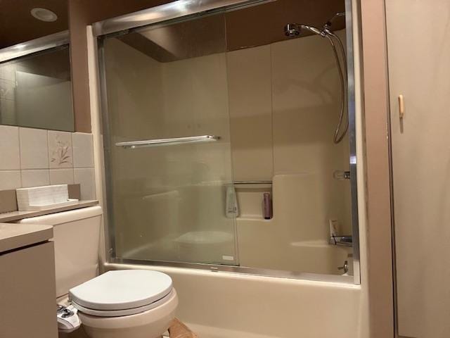 full bathroom with tasteful backsplash, vanity, toilet, and shower / bath combination with glass door