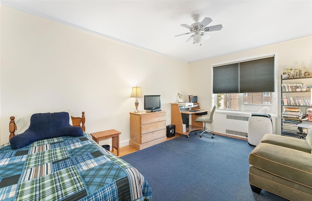 bedroom with ceiling fan and radiator heating unit