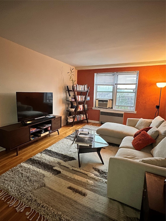 living room featuring hardwood / wood-style flooring, radiator heating unit, and cooling unit