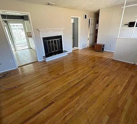 unfurnished living room featuring hardwood / wood-style flooring and a textured ceiling