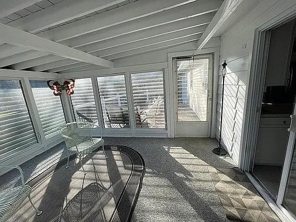 unfurnished sunroom with beamed ceiling