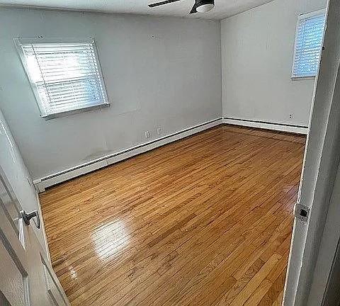 unfurnished room with hardwood / wood-style floors and ceiling fan