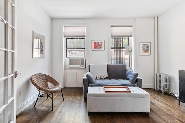 living room featuring dark hardwood / wood-style floors, radiator heating unit, and cooling unit