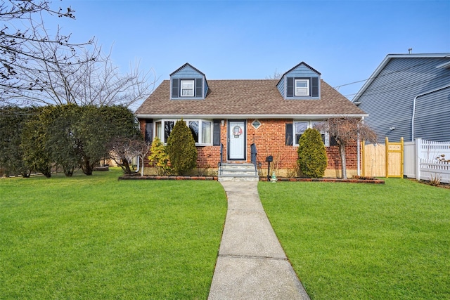 cape cod home featuring a front yard