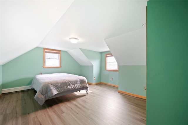 bedroom with baseboard heating, vaulted ceiling, and hardwood / wood-style flooring