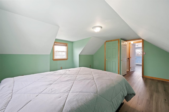 bedroom with hardwood / wood-style flooring and vaulted ceiling