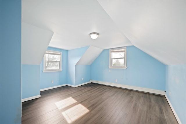 additional living space featuring a baseboard radiator, lofted ceiling, and dark hardwood / wood-style floors