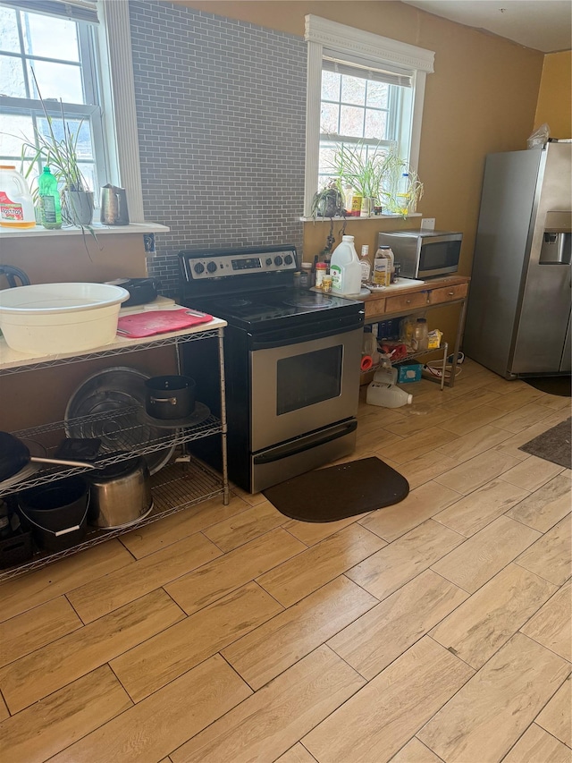 kitchen featuring appliances with stainless steel finishes and light hardwood / wood-style flooring