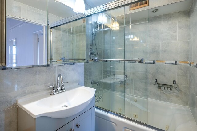 3725 Henry Hudson Pkwy Unit 6D, Bronx, NY 10463 - bathroom with vanity, shower / bath combination with glass door, decorative backsplash, and tile walls