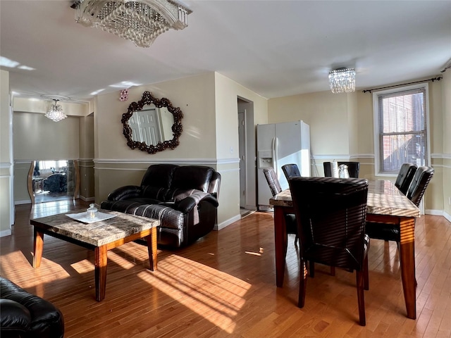 dining room with hardwood / wood-style floors and a chandelier