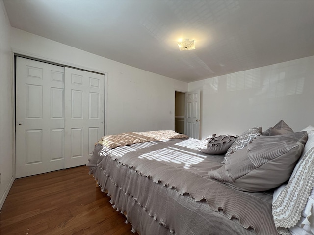 bedroom with dark hardwood / wood-style floors and a closet