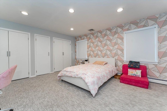 bedroom featuring multiple closets, a baseboard radiator, and light carpet