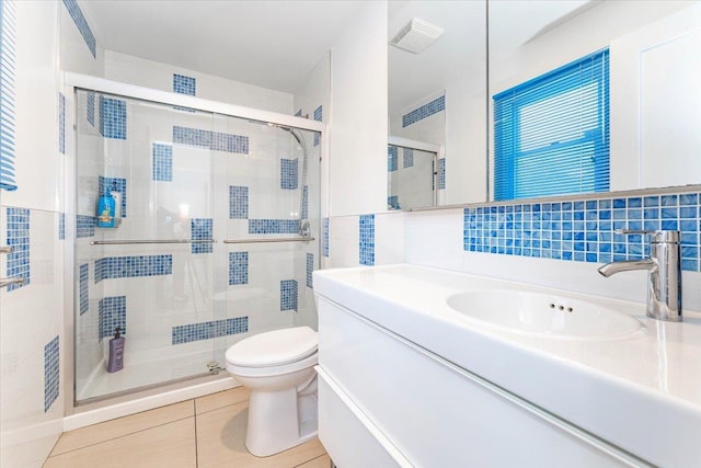 bathroom with walk in shower, tile patterned floors, toilet, tile walls, and vanity