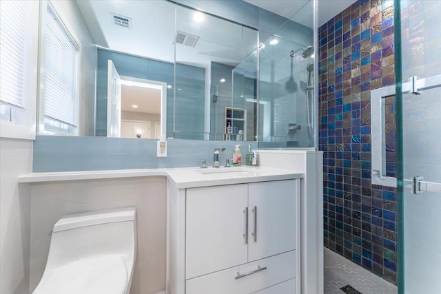 bathroom featuring vanity, a shower with door, tile walls, and toilet