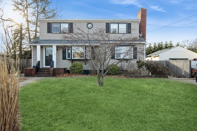 traditional-style home with a chimney, a front yard, and fence