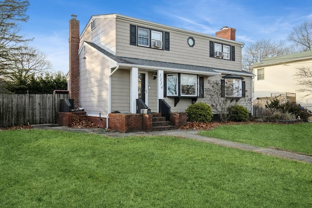 view of front of house featuring roof with shingles, a chimney, fence, and a front yard